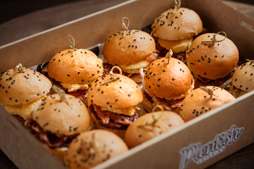 Mini bacon and egg sliders on soft milk buns, filled with crispy bacon, fluffy egg, and tomato chutney. Perfect for meetings and morning events. Delivery in Sydney and the Blue Mountains.